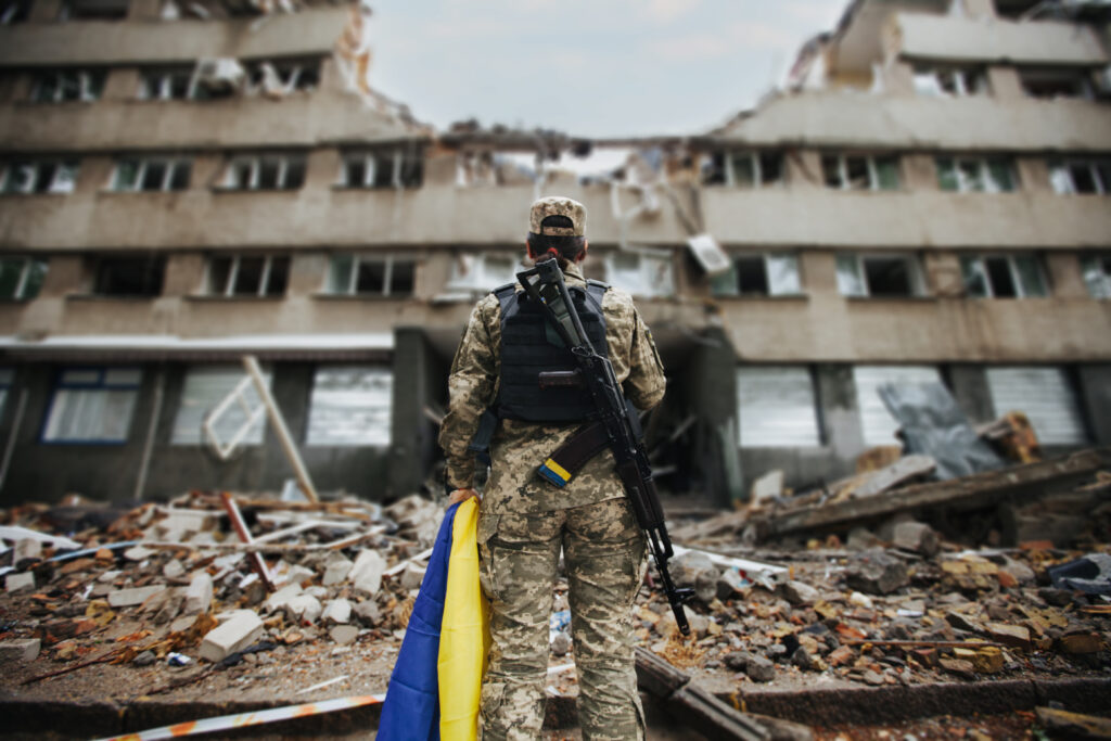 A soldier stands near a destroyed house war in u 2023 11 27 05 07 23 utc